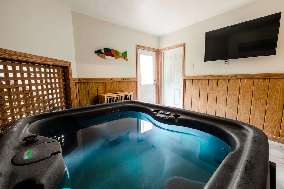 This image features a relaxing hot tub area accented by decorative fish wall art and a TV, blending the comforts of an indoor lounge with spa-like amenities. The tranquil surroundings create an ideal spot for soaking and socializing, alluding to the resort amenities discussed in the section.