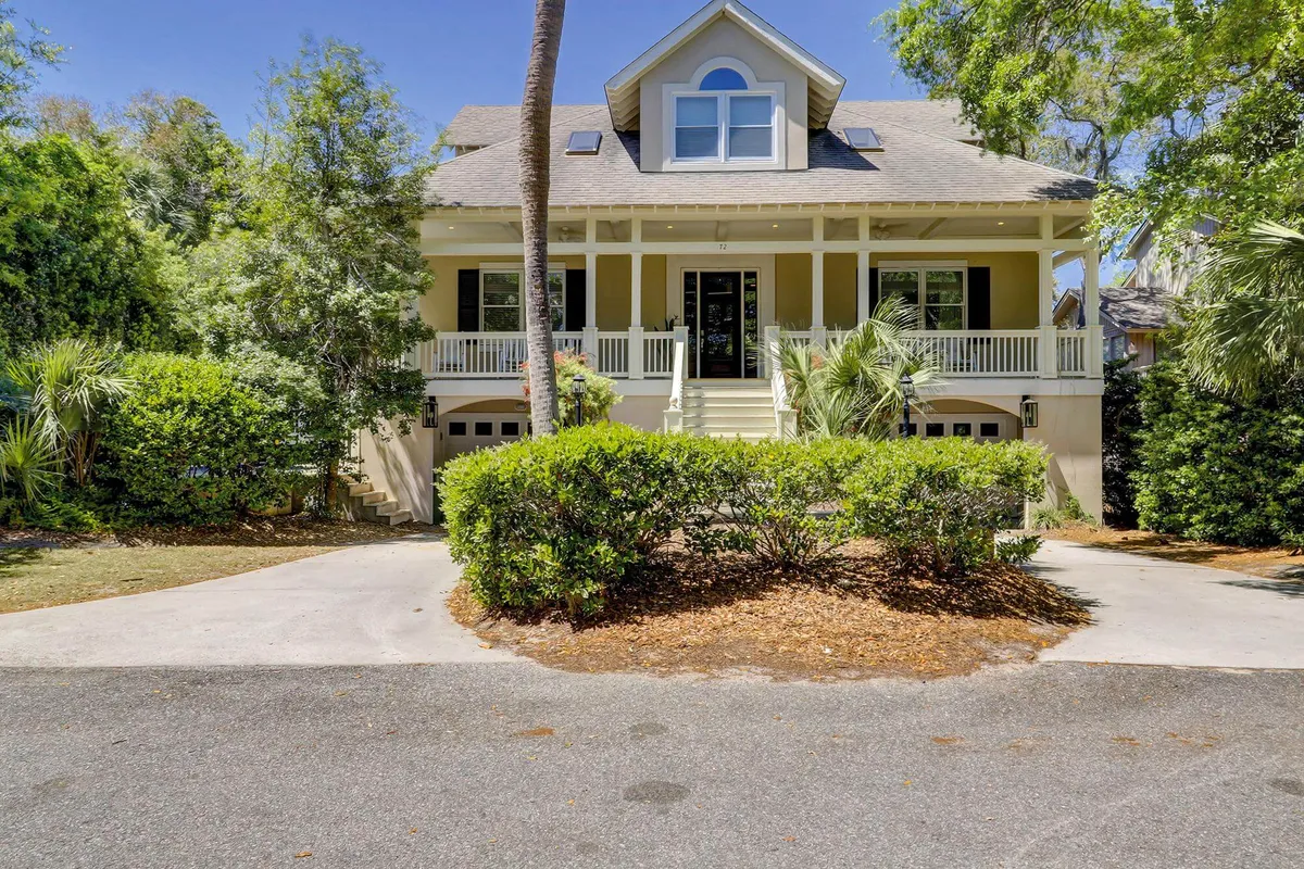 This image showcases the home's inviting front porch, symmetrical facade, and beautifully landscaped yard. The ample porch area and lush greenery set the scene for outdoor relaxation and socializing, embodying the resort-like ambiance described in the section.